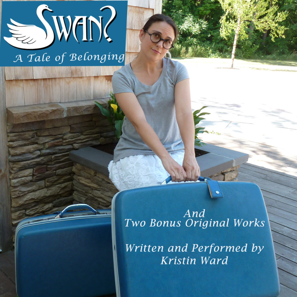 Storyteller Kristin Ward sits with blue Luggage. "Swan: a tale of belonging" and two other original tales.